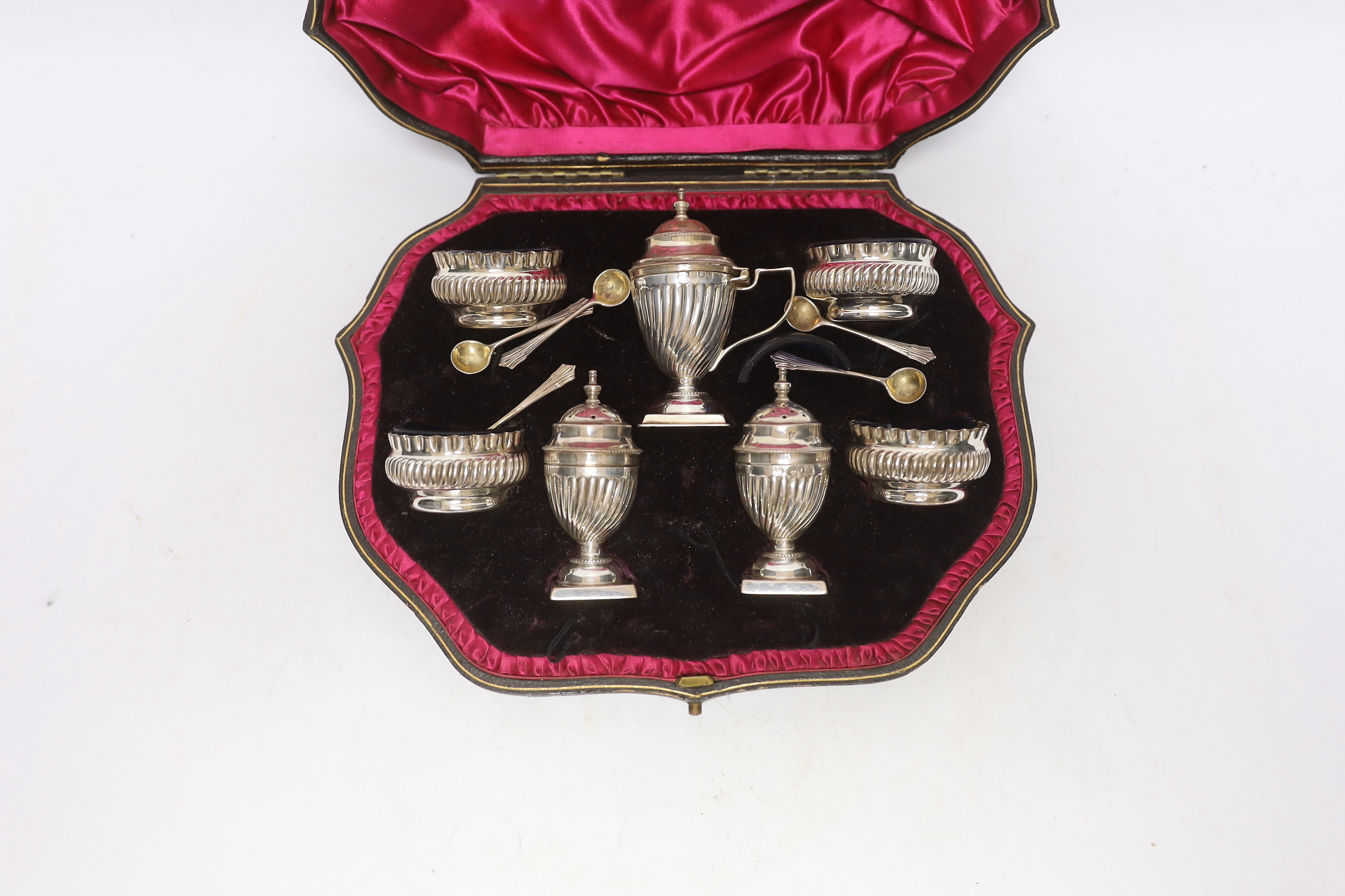 A cased late Victorian seven piece silver condiment set, Josiah Williams & Co Ltd, London, 1898, with five matching spoons.